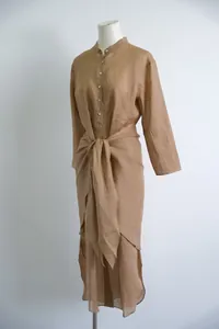 Zijaanzicht van een lange ramie jurk met opstaande kraag en wikkeldetail bij taille