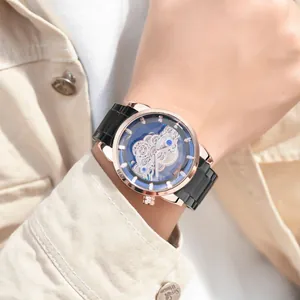 Stylish men's skeleton quartz watch with rose gold case and black band on wrist.