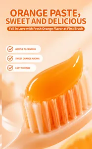 Primer plano macro de gel de pasta de dientes naranja translúcido en cerdas de cepillo.