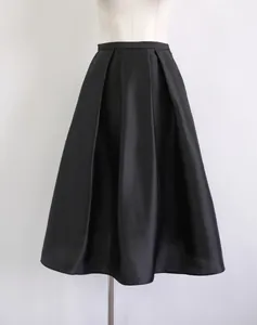 Detailed view of a black silk-wool blend pleated A-line midi skirt on a mannequin