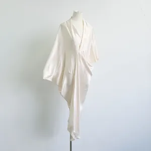 Elegante champagne acetaat jurk met gedrapeerde V-hals en vloeiende satijntextuur.