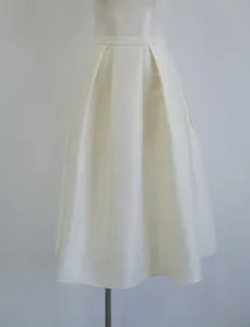 Close-up of pleated silk-wool blend A-line skirt in elegant macadamia color