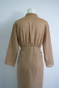 Achteraanzicht van een kameelkleurige ramie lange jurk met hoge taille en kraag