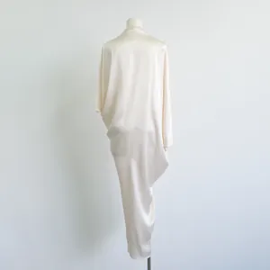 Elegante crème acetaatjurk met een verfijnd asymmetrisch gedrapeerd detail achter