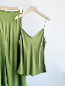 Detailed view of the olive green cupro silk camisole and matching skirt on hangers.