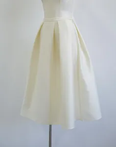 Detail shot of elegant macadamia pleated silk-wool blend A-line high-waist skirt
