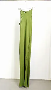 Dettaglio di un abito lungo in cupro verde oliva appeso su uno sfondo bianco minimalista.