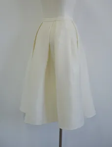 Close-up of elegant pleated A-line skirt in silk-wool blend macadamia color