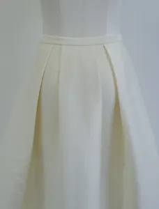 Detailed close-up of a nut-colored silk-wool blend pleated A-line skirt waistline.