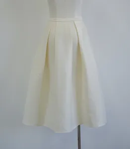 Close-up of macadamia cream silk-wool blend pleated A-line midi skirt on mannequin