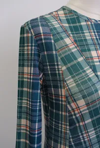 Primer plano detallado que muestra la textura y el patrón de cuadros verde azulado del vestido