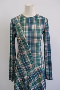 Detalle de un vestido largo ajustado de manga larga con cuadros verde y azul para mujer