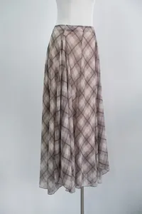 Detailed view of brown plaid midi skirt with irregular hem and flowing fabric.