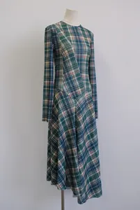 Detalle que muestra la silueta y el patrón de costura diagonal del vestido midi a cuadros