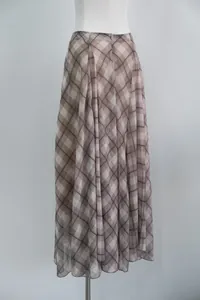 Detailed look at the flowing brown plaid fabric and irregular hem of this midi skirt