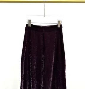 Detailed view of elegant dark purple crushed velvet casual trousers on a hanger