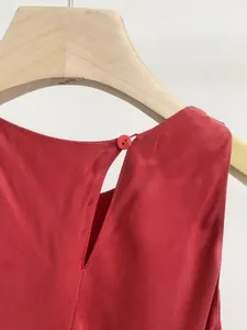 Dettaglio dell'apertura posteriore con bottone di un elegante vestito rosso