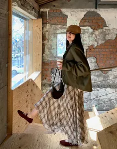 French chic brown plaid midi skirt with irregular hem shown in a lifestyle urban scene