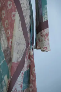 Detailweergave van de elegante bloemenprint en zijden textuur van deze Franse vintage jurk