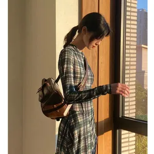 Vista lateral detallada de un vestido de diseñador de manga larga con estampado a cuadros