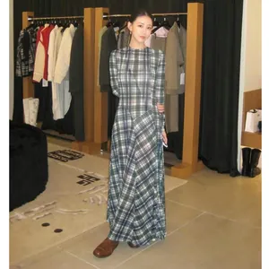 Vista de cuerpo completo de un elegante vestido largo a cuadros en una modelo en boutique.