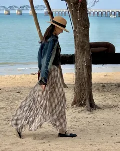 Elegant brown plaid irregular midi skirt flowing in a sunny beach lifestyle setting