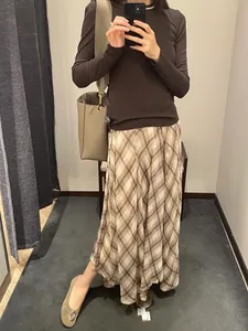 Model showcases a brown plaid irregular midi skirt featuring a graceful French style drape