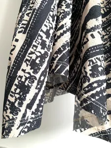 Primer plano detallado de la tela con estampado de letras abstractas en negro y beige