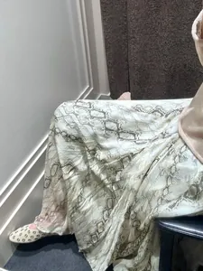 Close-up detail of snake skin pattern midi skirt with flowy irregular hem in soft fabric