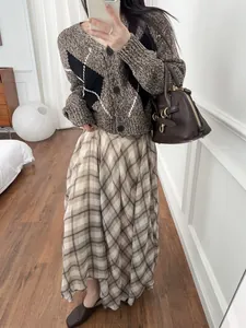 Elegant brown plaid midi skirt featuring an irregular hem and flowy French style drape.