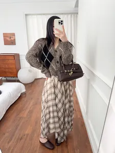 Detail view showing the flowing drape of this brown plaid irregular midi skirt.