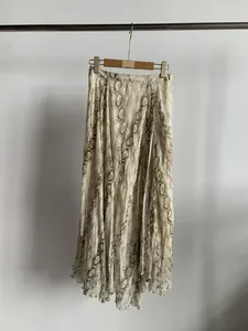 Elegant flowy snakeskin print irregular midi skirt hanging against a clean white wall.