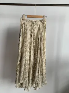 Elegant beige python print midi skirt with asymmetrical flowing hem displayed on a hanger
