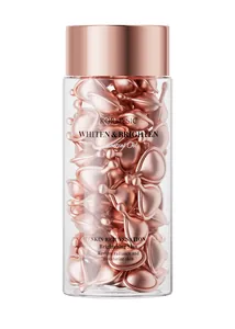 Close-up detail of rose gold skin rejuvenation serum capsules in a premium glass bottle