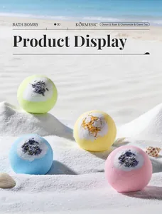 Bombas de baño de colores con flores secas sobre la arena de una playa soleada
