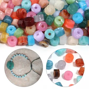 Vista de detalle de varias cuentas de barril de acrílico de colores para joyería DIY.