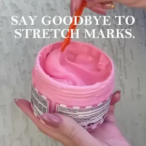 Adeus pink body heat cream jar for stretch marks with cream being stirred by tool