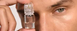 Makroaufnahme der Micro Infusion Phiole mit Nadelapplikator nah am Gesicht gehalten