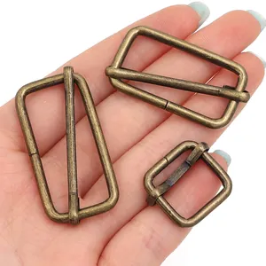 Vista detallada de tres hebillas deslizantes de metal bronce antiguo para bolsos