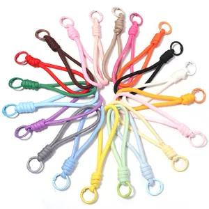 Détail montrant une collection colorée de cordons tissés avec des anneaux métalliques.