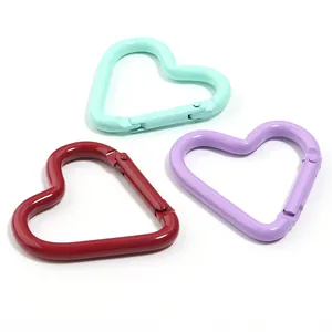 Primo piano di moschettoni a forma di cuore colorati in alluminio per portachiavi