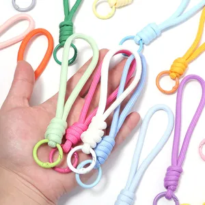 Gros plan de cordons en nylon tressés multicolores pour téléphones, tenus en main.