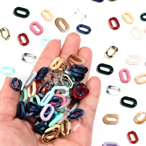 Detailopname van kleurrijke acryl U-vormige kettingstaven voor DIY-sieraden in de hand.