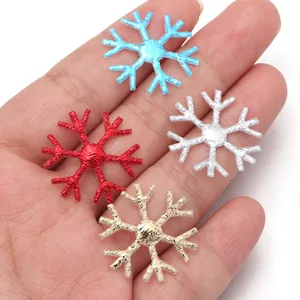 Vista detallada de parches metálicos de copos de nieve para decoración navideña DIY