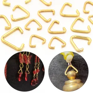 Vista detallada de conectores metálicos triangulares dorados para joyería DIY artesanal.