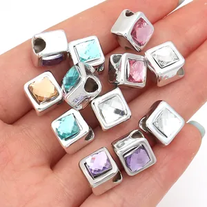 Close-up of square metal spacer beads with colorful faceted resin gemstones
