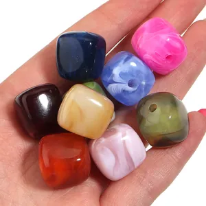 Primer plano de cuentas cúbicas de acrílico marmoleado colorido para bisutería DIY.