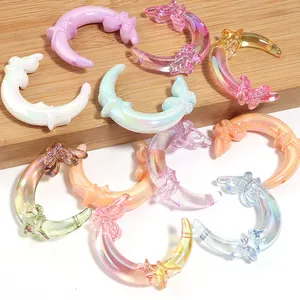 Detailed view of mixed iridescent resin moon and butterfly charms for DIY crafts