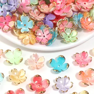 Close-up of colorful 3D five-petal flower charms with gold rims for DIY jewelry making