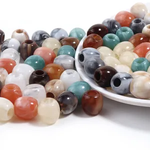 Primer plano de cuentas de acrílico de colores con agujeros para manualidades DIY